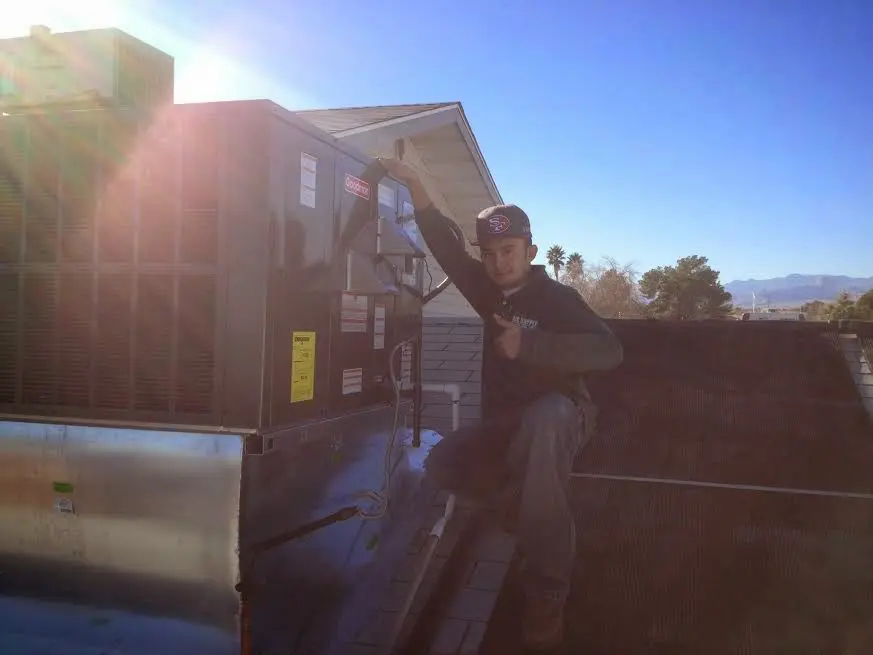 HVAC technician performing AC Tune-Up on a rooftop unit in North Las Vegas